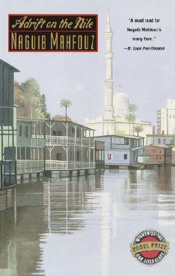 a water front view of a village with a mosque in the background.
